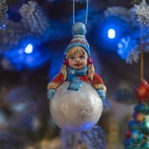 Елочная игрушка девочка лепит снеговика